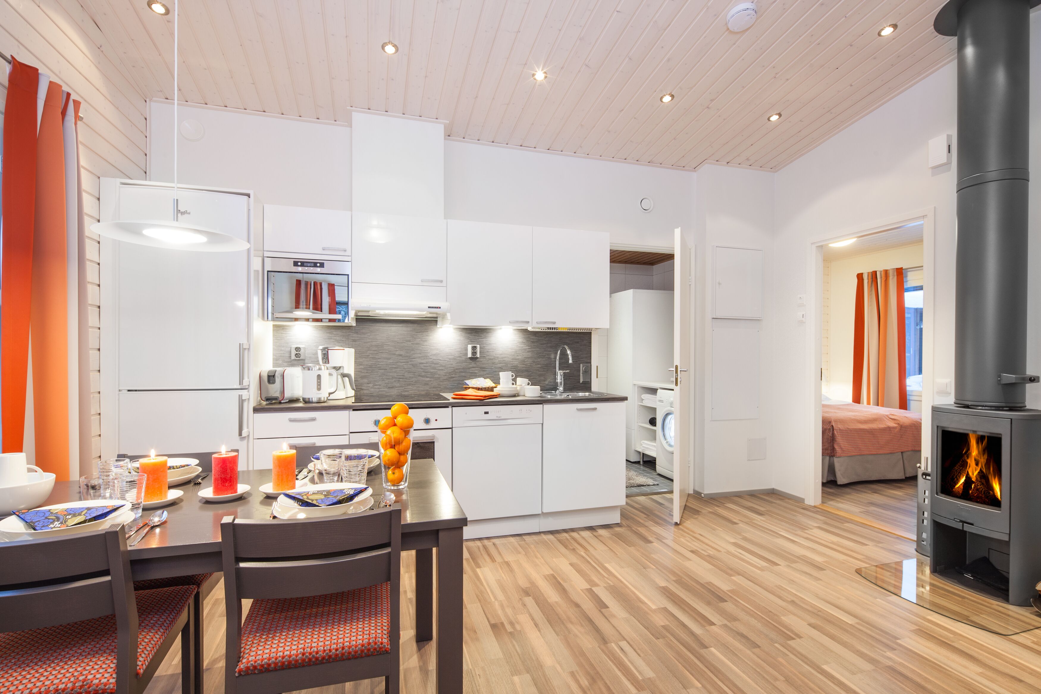 A modern kitchen with white cabinets, a built-in oven, and a central island with a sink.