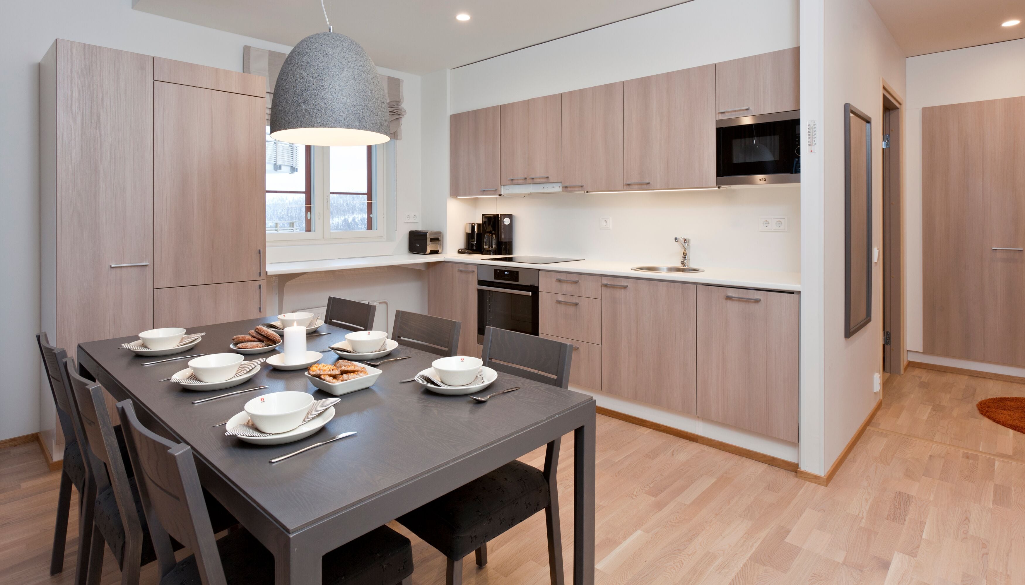 A modern kitchen with wooden cabinets, a built-in oven, and a microwave.