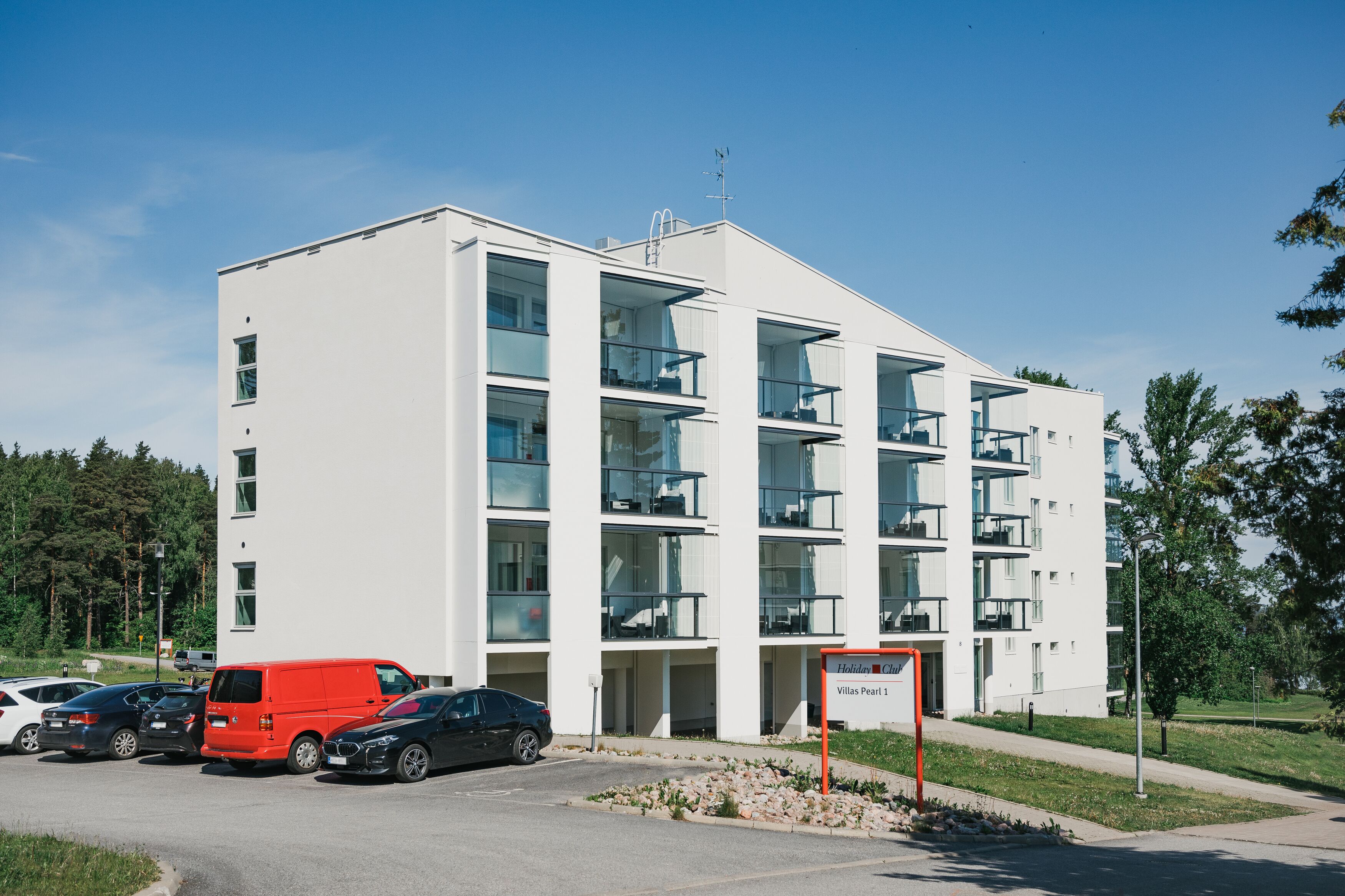 A modern multi-story hotel with balconies and a sign indicating "Villas Pearl 1".