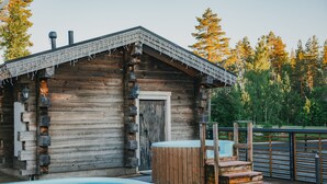 A rustic cabin with a wooden exterior, a pool, and a deck area.