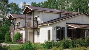 A two-story house with a balcony, large windows, and a garage.