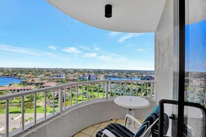A balcony with a view of a marina and a golf course.