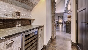 A modern kitchen with a stone accent wall, a long countertop, and a view into the dining area.