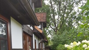 Ein traditionelles Fachwerkhäuschen mit einem gepflasterten Weg, der zu einer Tür führt.