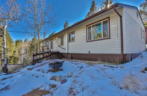 A single-story mobile home with a covered porch, a small front yard, and a snow-covered ground. - Cozy Cabin bordering Pikes National Forest  (Woodland Park)