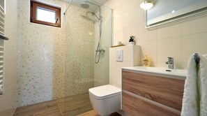 Regadera, secadora de cabello, toallas, papel de baño 