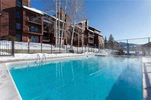 Guests can enjoy a refreshing swim in the pool surrounded by a secure metal fence.