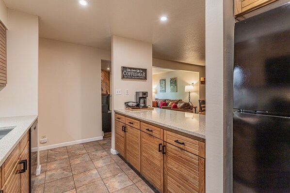 Enjoy a warm cup of coffee at the kitchen's coffee bar, complete with a coffee machine and countertop.