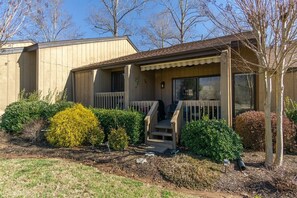 A single-story house with a front porch, a small garden, and a garage. - Fairway Villa 1304 at Rumbling Bald (Lake Lure)