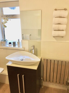 Bañera, secador de pelo, toallas y jabón
