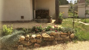 A rustic building with a stone wall and a wooden pergola. - Berrichonne character house (St Jeanvrin)