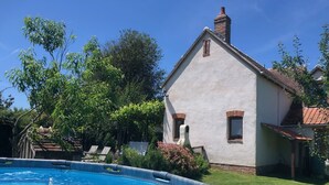 A house with a swimming pool, surrounded by greenery and a clear sky. - Berrichonne character house (St Jeanvrin)