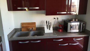 Una cocina con un lavamanos doble, un tostador y una cafetera.