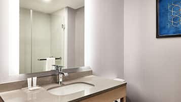 Une salle de bain moderne avec un grand miroir, un lavabo et un porte-serviettes.