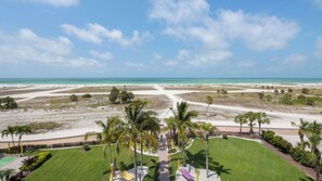 Un paisaje costero con playa, palmeras y cielo despejado.