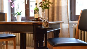 A dining table with a vase of flowers, a bottle of liquor, and a wine glass. - REISEKULTOUREN Apartment PAULINE in the center of Detmold (Detmold)