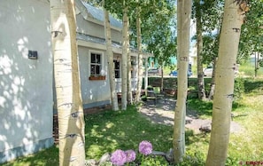 Fileira de casas brancas com gramado e algumas árvores.