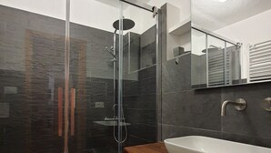 A modern bathroom with a glass-enclosed shower, a white sink, and a mirror above the sink. - Sweet Home ski out (Valtournenche)