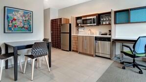 Cocina moderna con comedor, que incluye un refrigerador, microondas y lavavajillas.