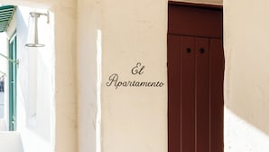 A corridor with a white wall and a brown door, with the text 'El Apartamento' indicating a residential area. - Palihouse Santa Barbara (Santa Barbara)