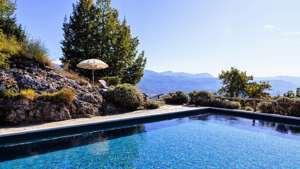 Une piscine d’eau cristalline, avec une vue sur les montagnes en arrière-plan.