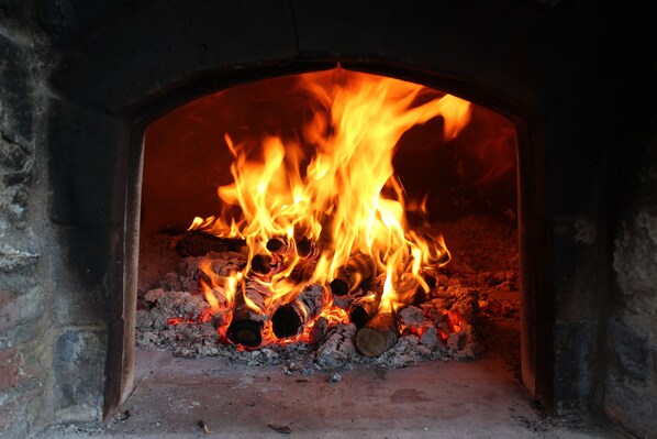 A brick oven with a fire burning inside. - La Fattoria Farmhouse with La Stalla Apartment (Sleeps 14, 7 Bedrooms) (Promiana, Molazzana, Lucca ,Toscana)