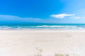 A beach with a clear sky and calm sea.