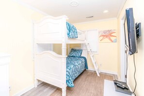 A bunk bed with a ladder, a television mounted on the wall, and a starfish artwork. - Blue Tortoise - Awesome Oceanfront Deck!  Dog Friendly! (North Topsail Beach)