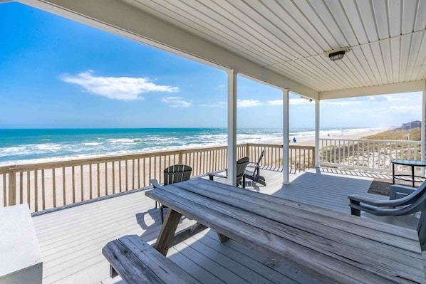 A wooden deck with a view of the ocean and beach.