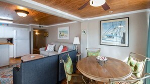 A cozy living area with a wooden ceiling, a round dining table, and a sofa. - Wanna Sea #201 - Newly Constructed Balcony! (Fernandina Beach)
