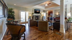 A spacious living room with a fireplace, comfortable seating, and a dining area.
