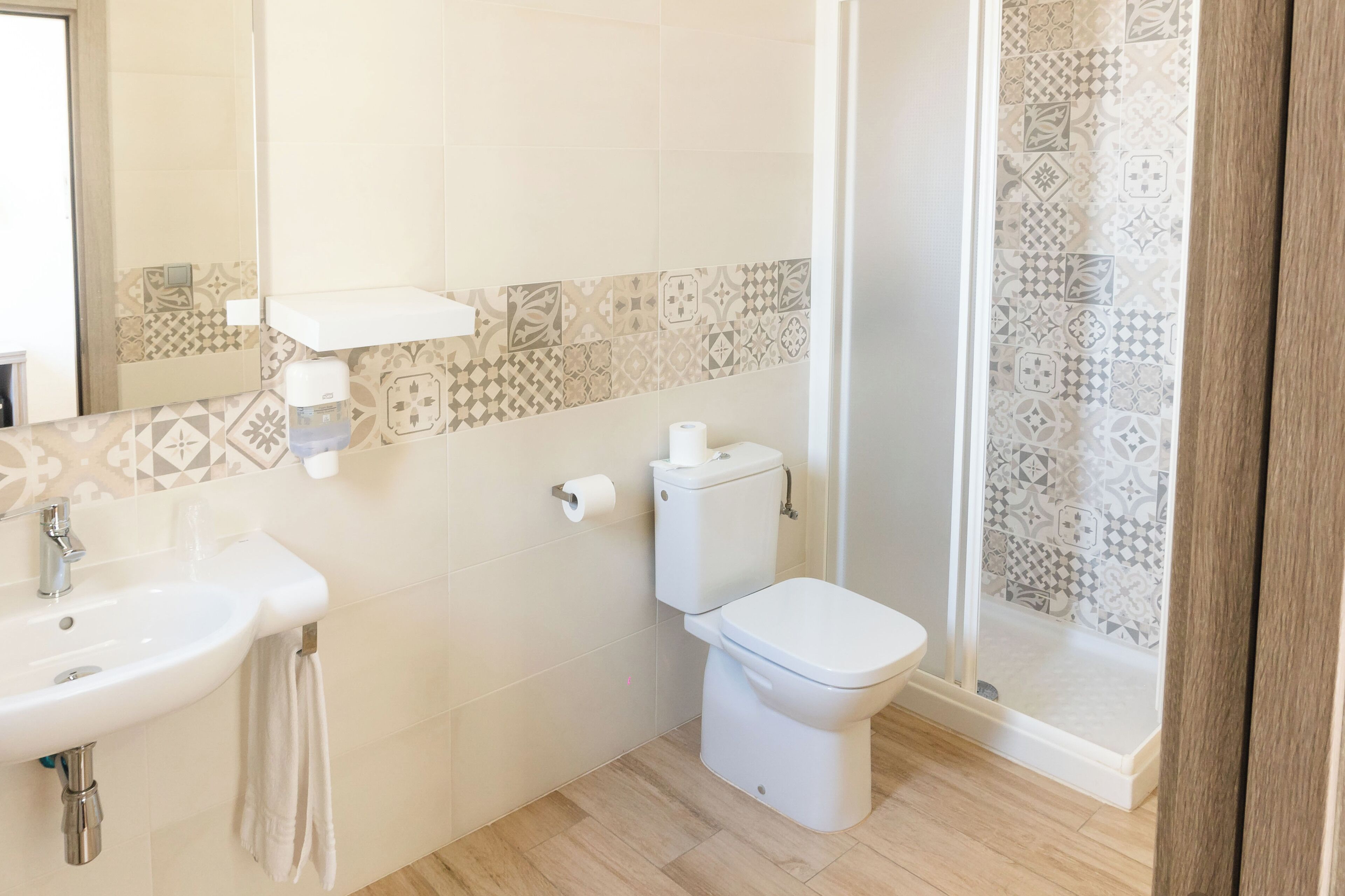 A bathroom with a sink, toilet, and shower area.