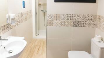 A bathroom with a sink, toilet, and shower.
