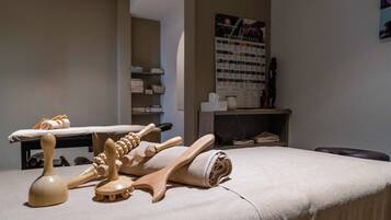 A room with a massage table, wooden massage tools, and a poster on the wall.