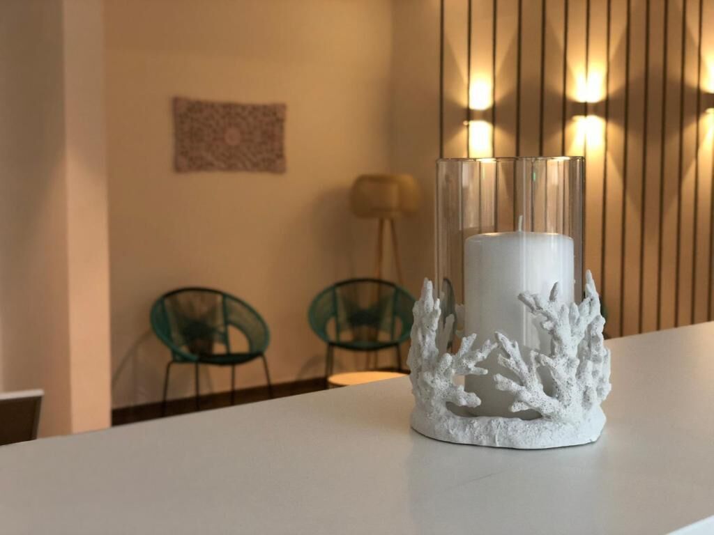 A white candle holder with a coral design on a table.