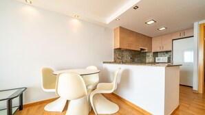 A modern kitchen with wooden cabinets, a central island, and a microwave.