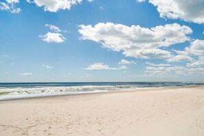 Ein Strand mit blauem Himmel und Wellen im Meer.