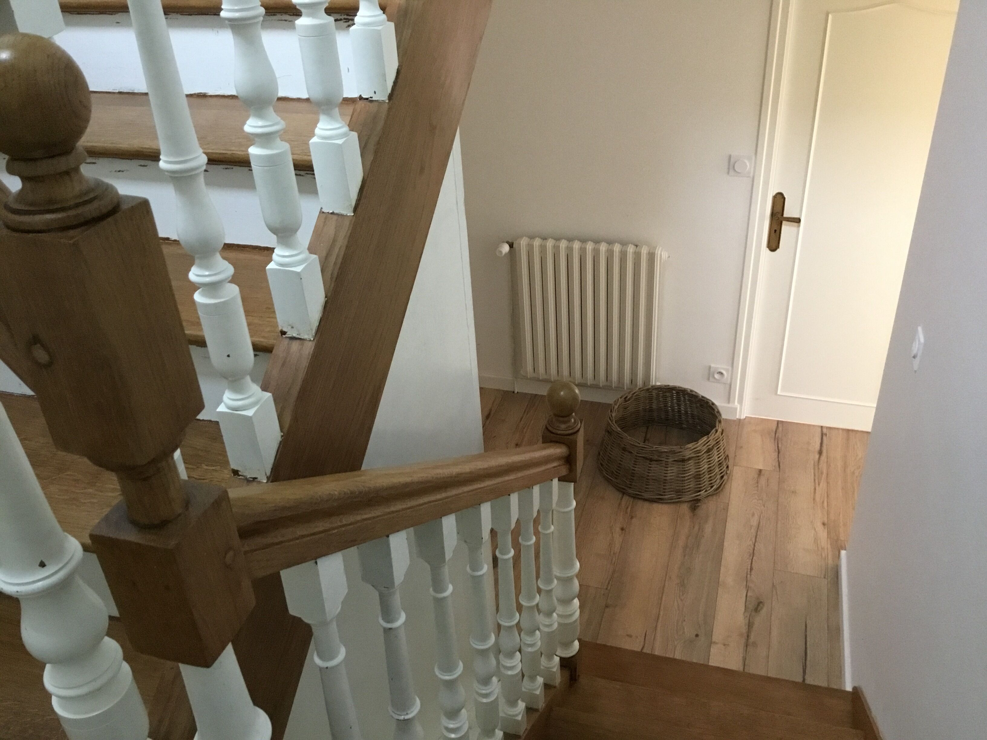 A wooden staircase with white balusters and a wooden handrail.