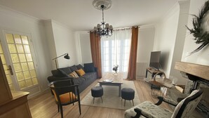 A modern living room with a sofa, chairs, a coffee table, and a fireplace. - Country by the sea! (Tréflaouénan)