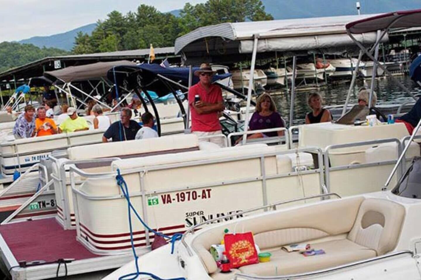Un port de plaisance où sont amarrés plusieurs bateaux, dont l’un porte l’inscription « VA-1970-AT » et un autre affiche le mot « SUPER SLIMMER » sur sa coque.
