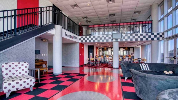 A spacious lobby with a checkered floor, a piano, seating areas, and a visible staircase leading to an upper level. - Haven of Rest at Bristol Motor Speedway, Unwind (Bluff City)