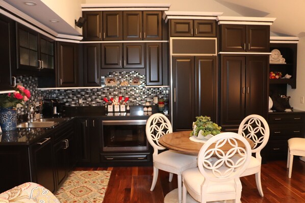 Enjoy cooking in this well-equipped kitchen with a central island, black and white backsplash, and stainless steel appliances.