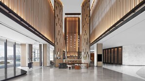 A spacious lobby with a central bar area, large windows, and a modern architectural design. - JW Marriott Shanghai Fengxian (Shanghai)
