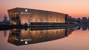 A JW Marriott hotel with a modern design, featuring a large reflective pool in front. - JW Marriott Shanghai Fengxian (Shanghai)