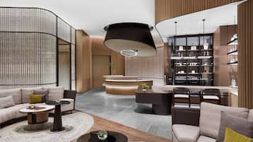 Relax in our inviting lobby, featuring a comfortable seating area, a reception desk, and a bookshelf with neatly arranged items.