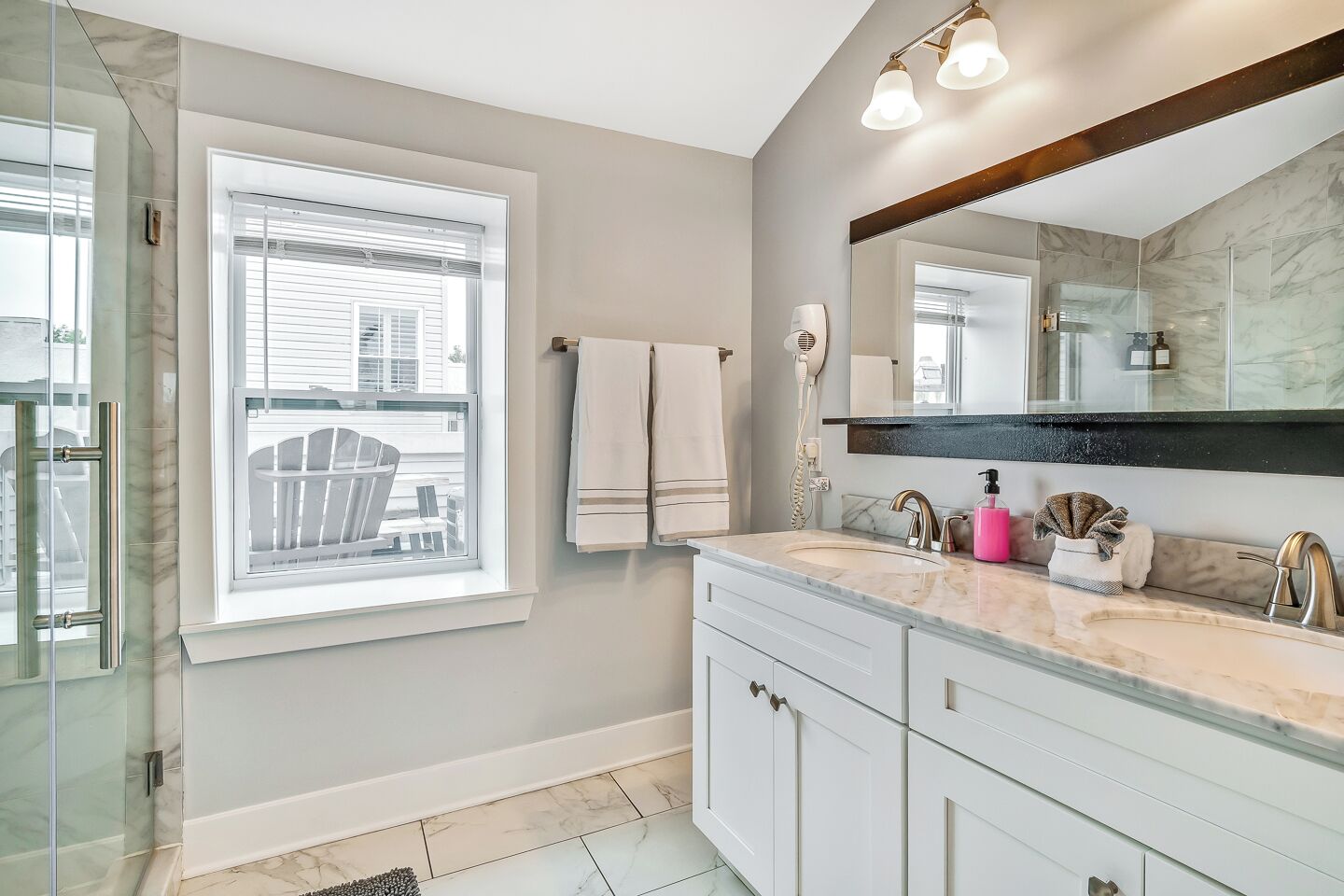 A modern bathroom with a large mirror, a vanity with a sink, and a shower area.