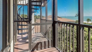 Un balcon avec vue sur la plage et l’océan.