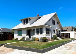 Une maison à deux étages, dotée d’un toit à pignon, d’un porche à l’avant et d’une pelouse bien entretenue.