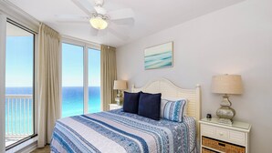 A bedroom with a bed, a nightstand, a lamp, a ceiling fan, and a view of the ocean. - Coastal 12th Floor Beachfront Condo w/ Close Dining & Shopping in Destin! 🌊🌴💙 (Destin)
