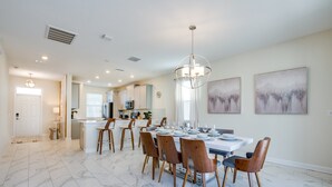 A spacious dining area with a marble floor, wooden chairs, and a central chandelier. - New Listing! Champions Gate Resort, 10mi to Disney & 21mi to Universal - FS277323 (Davenport)